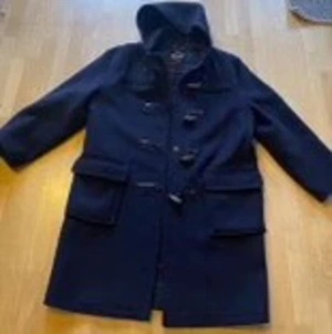 Mörkblå Gloverall  duffel  - Mörkblå duffel från Gloverall, i mycket fint skick och utmärkt kvalitet. Tillverkad i UK, inköpt på Ströms. Nypris ca 4500 kr. Väldigt lite använd. Mycket varm men andas. 80 % ull, 20 % nylon.