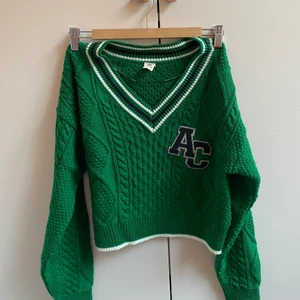 AC tröja från Urban outtfitters - Säljer den här så fina cropade, v-ringade AC tröjan från Urban Outfitters. Använd endast en gång och är i super bra skick! Köpt för 600kr