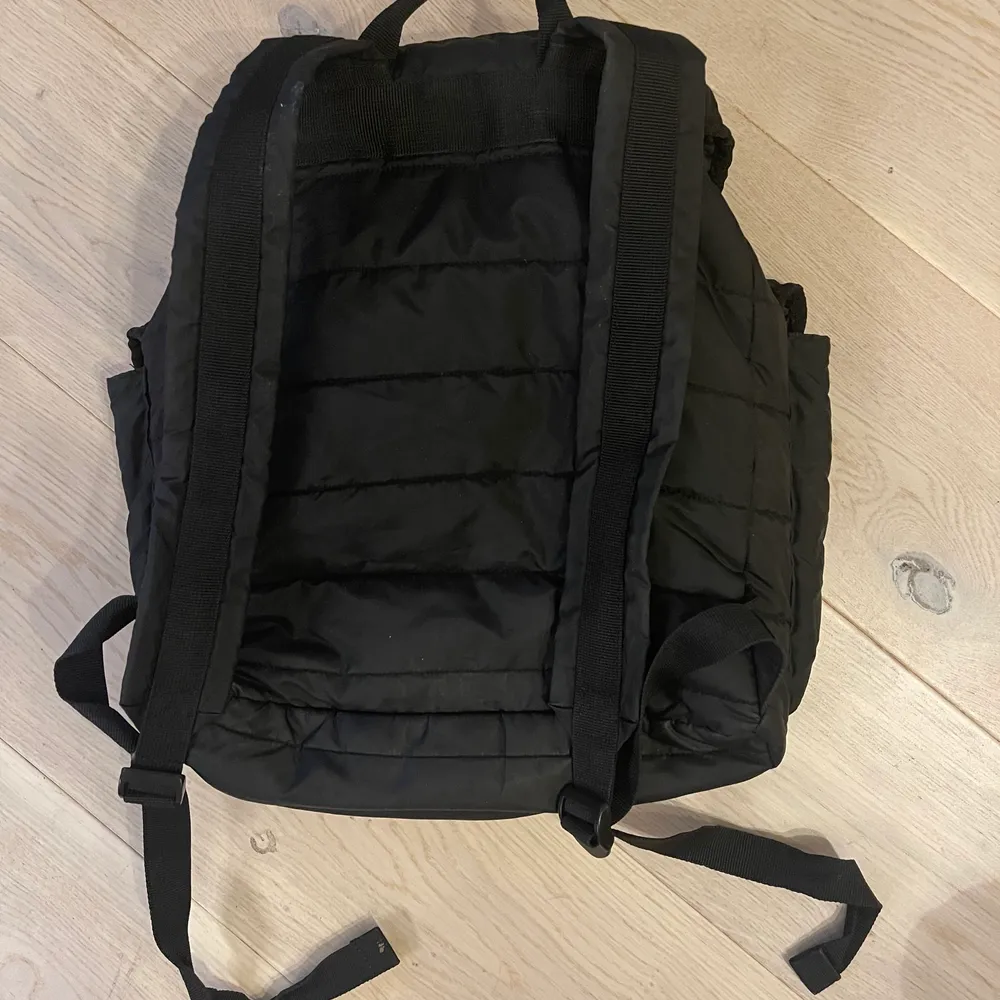 Vadderad ryggsäck i svart, från Uniqlo. Väskor.