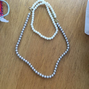 Vitt och grå/lila pärlhalsband  - Ett fint pärlhalsband som både är vit och grå lila. Har aldrig använt halsbandet. Den går inte att dubbelvika eftersom den är för kort för det, men den är ändå rätt lång i längden. Frakt ingår ej