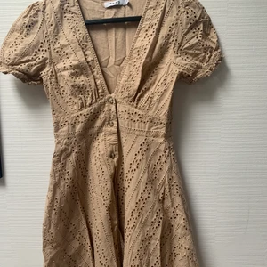 Beige sommarklänning  - Fin beige sommarklänning från Na-Kd, storlek 36. Endast använd en gång. Knäpps med knappar längs framsidan. Tight upptill och lite utsvängs nertill. 