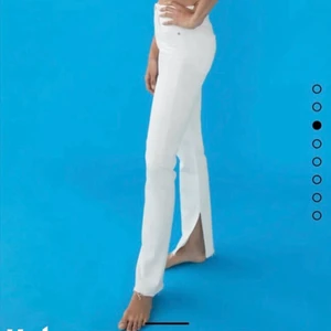 Zara jeans med slit - Ett par vita zara byxor med ett litt nedantill som nu är slutsålda i butik. Byxorna har endast används vid et få tillfällen då de är för långa på mig (är 158). Byxorna är i storlek 32 men sitter skut fint på mig som har storlek 34.