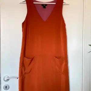 Orange klänning med fickor från H&M. Storlek 36