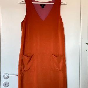 Orange klänning - Orange klänning med fickor från H&M. Storlek 36