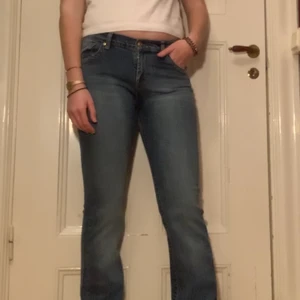 Bootcut jeans - Mellanblå bootcut jeans med ascoola detaljer på byxfickorna. Fick inte med nederdelen av byxorna på bilden så kontakta gärna för fler bilder och mer specifika mått! Köpta av min mamma på 00-talet och i princip jelt oanvända sen dess. Nyskick! 