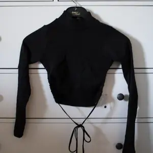 En jättefin svart långärmad tröja med öppen rygg, perfekt till fest eller middag