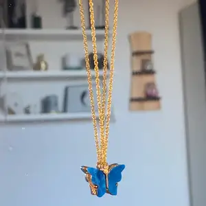 Ett guld halsband med en blå fjäril på!🦋 bild 2 är där man sätter ihop halsbandet!📦💕