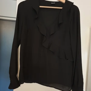 Svart blus i storlek 38 - Fin blus med volang🎉 Lite genomskinlig i materialet men tycker inte det märks när man har på sig den 😊
