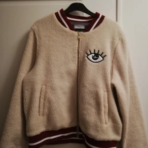 Fluffig jacka  - Fluffig jacka med tryck på ryggen. Märket är j1mo71. Storlek M. Varm och skön till både hösten och vintern. Inte jättemycket använd denna heller. Dock har knapparna i fickorna lossnat (kolla bild). Går säkert att fixa med rätt kunskap. 