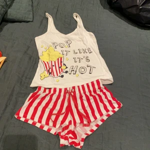 Pyjamas S - Gullig pyjamas med popcorn tema. På tröjan står det ”POP IT LIKE IT’S HOT”. Linnet är i storlek 34-36. Shortsen är i XS.