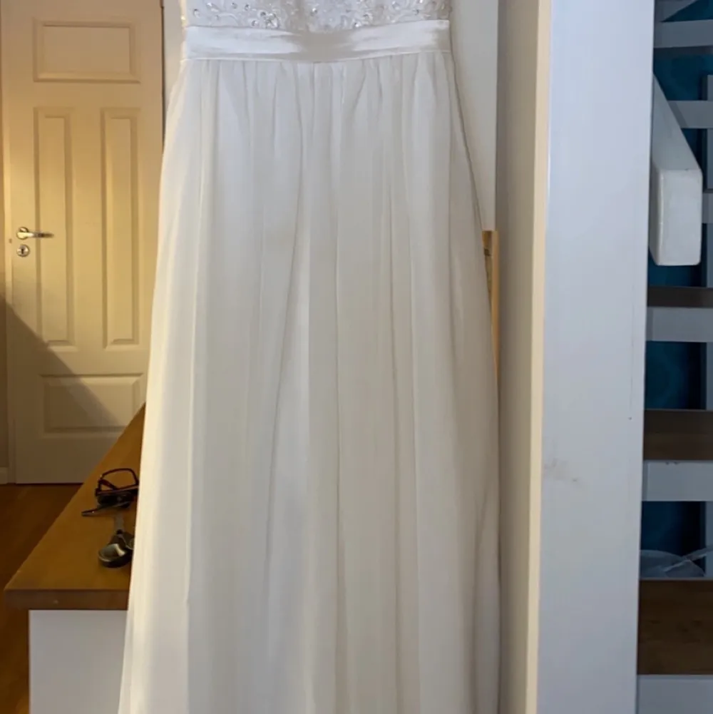 En jätte fin vit lång klänning som passar till fester,bal,student och dop den är så fin och använd bara en gång och den ser som ny ut det är i storlek 38 och är så fin och elegant tycker jag och den har en jätte fin bak jag säljer den för 900 och orginial pris är 1700. Klänningar.