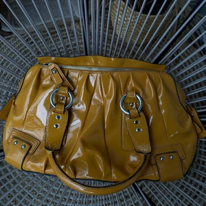 Trendig handväska från Karen Millen - Gul väska från Karen Millen. Dustbag ingår. Mycket bra skick. Inga synliga defekter. Perfekt till skolstart och nu i höst!             Beredd: 35 cm.  Djup: 12,  höjd 25 cm. 