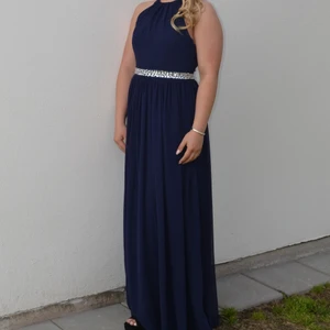 Balklänning  - Balklänning i nyskick, använd 1 gång. Storlek 10Uk estimeras som S/36 EU. Känningen är uppsydd, jag som bar klänningen är 160 cm lång och hade på mig 12 cm klackar men klänningen snuddat precis marken med det. 