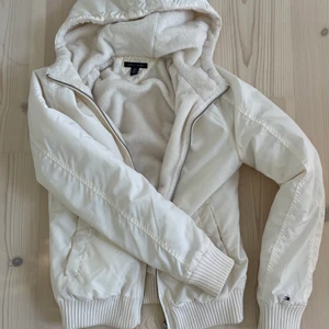 Tommy Hilfiger Jacka - Vit Tommy Hilfiger jacka i storlek xs. Supermysigt material på insidan och ”glansig nylon” på utsidan. Med luva. Använd men i bra skick! 