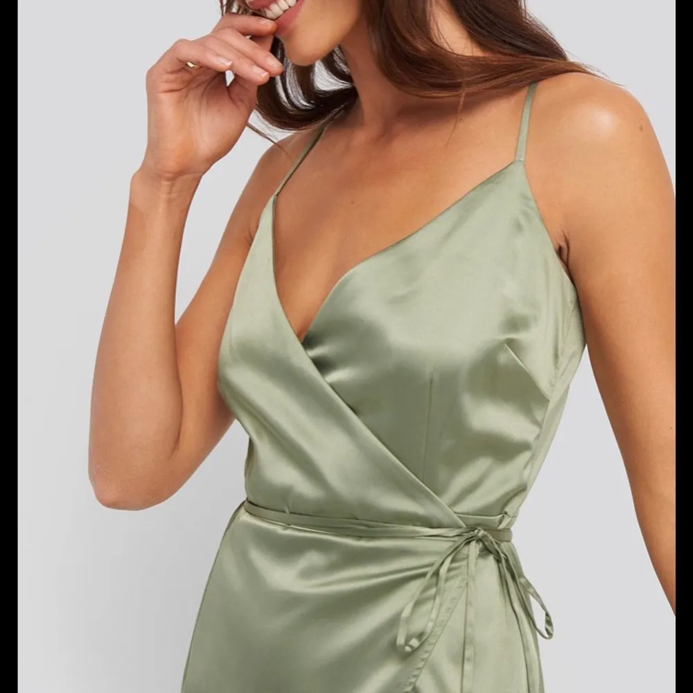 En vacker grön klänning i silkes material, använd en gång så den är som gott som ny. Storlek m men är stor i storlek, men man kan justera med snöret i midjan ✨. Klänningar.