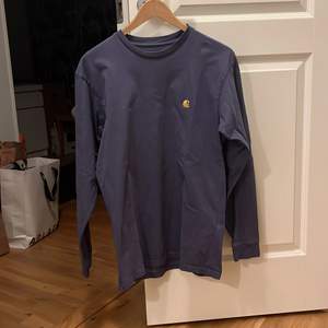 Säljer min måttligt använda långärmade T-shirt från carhartt i en blå/grå färg. Den säljs för att den är för liten. Passformen är ganska smal och längden normal. 