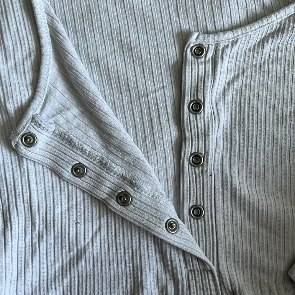 Kort vit tröja från asos. Det finns ett 3 mm hål på framsidan som inte märks av pga plaggets ränder . Toppar.