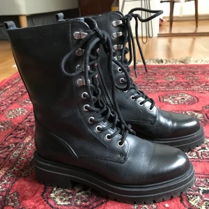 Svarta kängor  - Fina svarta länderkängor i st 38. Endast använda en gång. Säljer pga för små för mig. De är fodrade på insidan. Ordinarie pris 900kr