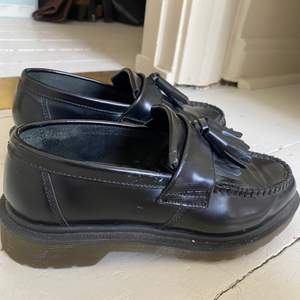 Loafers i svart läder från Dr Martens. Något använda i skinnet men i övrigt är dem i bra skick. Storlek 37.
