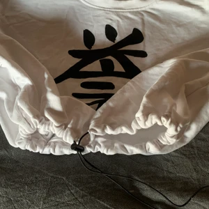 Vit t-shirt med ett tryck på - En vit t-shirt med ett svart tryck på! Köpt på new jorker men aldrig använt den för det är inte min stil! Storlek XS-S, man kan dra åt i midjan! 90 kr!