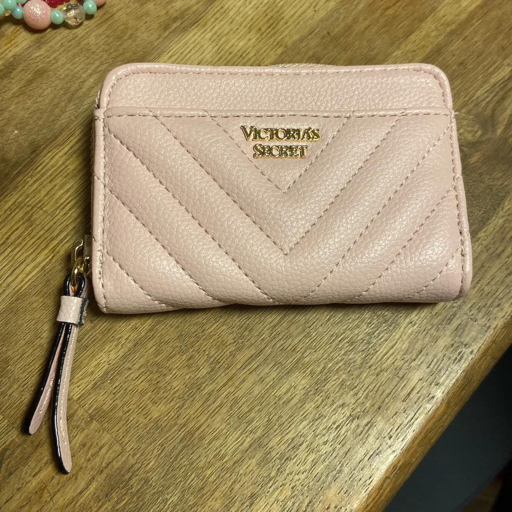 En ny Victoria secret plånbok använd ca 2 gånger så är i ny skick, baby rosa färg med guld detaljer. 7 små kort fack och sen 2 st större. Dragkedjan är kvar med sin detalj. . Accessoarer.