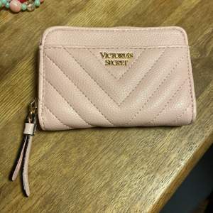 En ny Victoria secret plånbok använd ca 2 gånger så är i ny skick, baby rosa färg med guld detaljer. 7 små kort fack och sen 2 st större. Dragkedjan är kvar med sin detalj. 