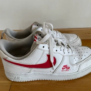 Nike Air Force 1 - Vita Nike Air Force 1 med rött Nike märke. Bra skick men lite slitna.
