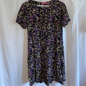 Blommig klänning - En blommig klänning i underbart skick. Den har en knapp där fram, men annars väldigt simpel modell. Klänningen är otroligt skön och i mjukt tyg. Fler bilder finns vid intresse. 