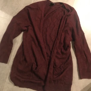 Vinröd kofta - Fin lång stickad vinröd kofta, går lite förbi rumpan☺️ hör av er vid frågor eller om ni önskar fler bilder🥰