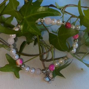 Armband  - Armband i rosa och vita pärlor med en fjärilsberlock. Denna säljs för 25kr+12kr frakt 
