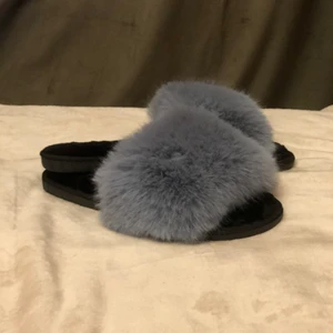 Tofflor i gråblå  fuskpäls storlek 38  - Ett par helt nya tofflor i gråblå fuskpäls från Shein. Skorna har innermått 25,3 vilket motsvarar storlek 38 europeisk tabell (Dock är de köpta som asiatiska 40). Mycket bekväm modell i bra kvalitet enligt min dotter som har flera par :) 
