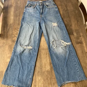 idun wide jeans - mörkblå utsvängda jeans med hål från gina tricot, väl använda och i bra skick!