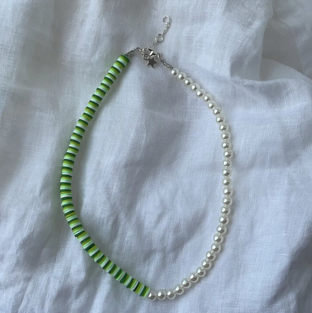 Superfint handgjort halsband med hälften gröna pärlor och hälften benvita. Förslutning bak med lås och tre ringöglor för justering samt en silvrig stjärna. . Accessoarer.