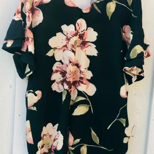 Blommig klänning, New Look - Inköpt för 3 år sedan på Nelly (tror jag), använd endast ett par ggr. Lös och ledig i modellen, knäkort. 