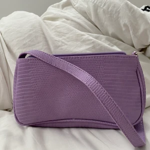 Lila väska  - Säljer nu denna fina väskan då den inte kommer till användning. Väskan är aldrig använd där av väldigt bra skick. Frakt ingår i priset! 