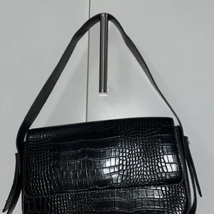 Snygg svart handväska knappt använd - Superfin slutsåld väska från bikbok. Perfekta handväskan , i läder och skinnimitation därmed snyggare, väldigt rymlig. Ordinariepris 399:-