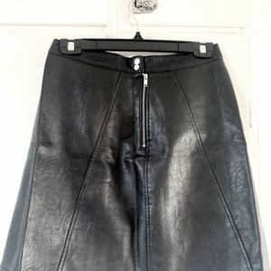 Skinnkjol, zara  - Svart a-linjeformas kjol i skinnimitation, från zara. Nyskick. Storlek S. Stängs med dragkedja och knappar. 