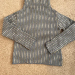 Ljusblå stickad tröja - En jättefin ljusblå stickad tröja med krämvitt mönster. Det krömvita är inte lika gult i verkligheten. Storlek 38/40 men skulle nog mer säga 36/38. Hög polokrage som även går att vika ner💖