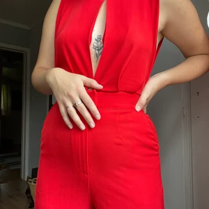 Röd byxdress - Säljer min skitsnygga byxdress från Bikbok. Inköpt för några år sedan, men endast använt den en gång, då den inte riktigt är min stil. Har därför bestämt mig för att sälja den till någon där den kan få bättre användning!  Den är i storlek XS, men passar mig som vanligtvis har storlek S, eller 36. Benen är ankellånga (på mig som är 163cm).  Köparen står för frakt. Kan även mötas upp i Stockholm, eller Dalarna.