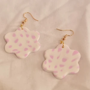 Blomörhängen - nr 10  - Blomform, vit bakgrund med rosa mönster. Handgjorda örhängen utav polymer lera med guldhänge, ca 3-4 cm i diamanter. 79kr + 20kr frakt 