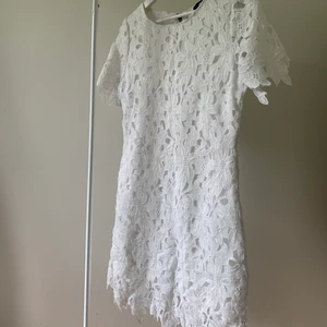 Vit klänning från Nelly storlek S - Vit klänning i blommigt material med en innerklänning som sitter fast i tyget. Inköpt från Nelly, se bild för märke. Storlek S. Inger att anmärka på, använd endast enstaka gånger. 50 + 66kr inkl frakt.! 