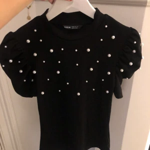 Svart topp med pärlor och puff armar  - Säljer denna svarta topp då jag aldrig använt den. Den är alltså i väldigt har skick✨