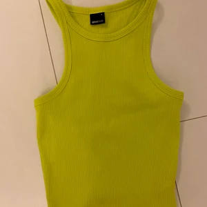 Topp  - Säljer denna as fina neon gröna topp från Ginatricot som är i strl S. Den är som ny då jag köpte den i somras alltså har den inga fläckar, hål osv. Säljer denna då de inte är min stil och jag inte har någon användning av den🤎