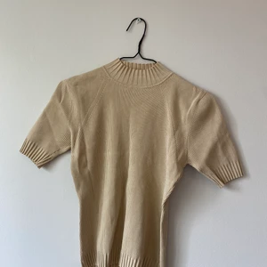 Ribbad t-shirt - Ribbad t-shirt med hög hals - snygg beige/höst färg. Sitter snyggt mot kroppen. Väldigt bra skick och god kvalitet. Stilren. 
