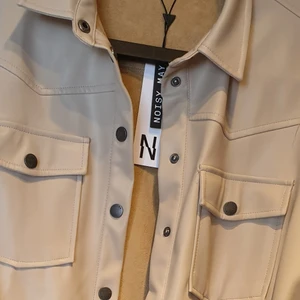 Ny skjortjacka noisymay - Helt ny med lapp kvar, storlek medium, kan användas med eller utan skärpet till. Konstskinn material. 