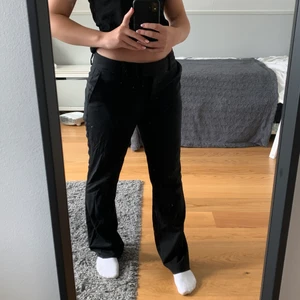 Lågmidjade Kostymbyxor - Ett par lågmidjade kostymbyxor med utsvängda ben. Endast använd en gång och är i nyskick. Köparen betalar för frakt :)