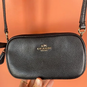 Fin Coach väska - Jättefin väska från Coach i svart läder, modell Polished Pebble Kira Crossbody. I perfekt skick. Remmen kan tas bort och väskan kan användas som plånbok/clutch.  Nypris: 2045.  Köparen står för frakten. 