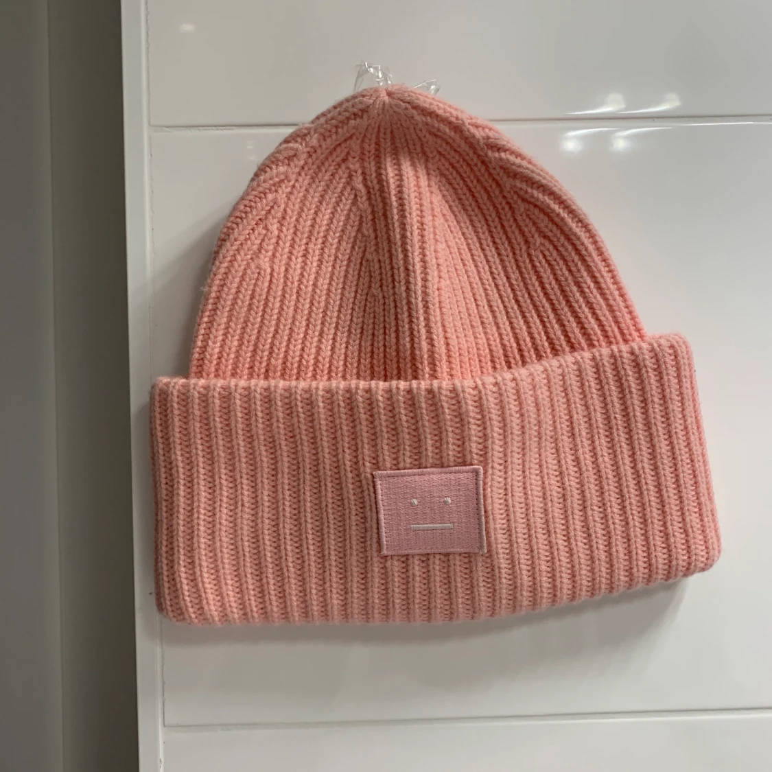 Ljusrosa acne mössa.