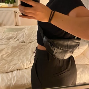 Svart magväska - Magväska i läderimitation. Köparen står för frakt!