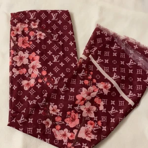 Sjal - En röd sjal som man kan styla på olika sätt. Den är helt ny och oanvänd!                                                                         Frakt tillkommer! 